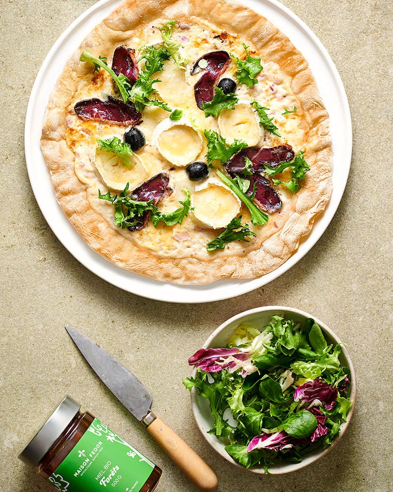 Pizza maison chèvre miel et magret fumé.