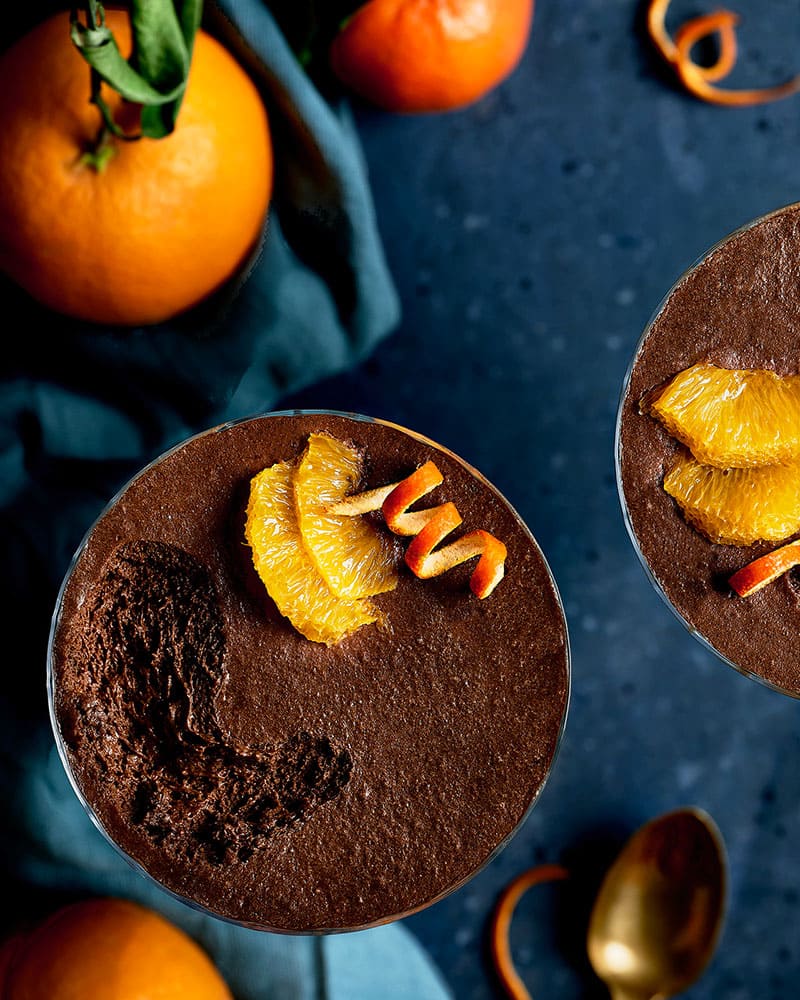 Gros plan sur une mousse chocolat, orange et miel entamée avec une cuillère.