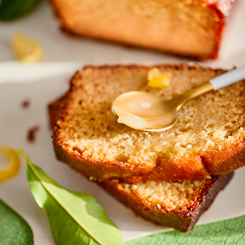 Texture moelleuse du cake au miel citron et vanille avec cuillère de miel.