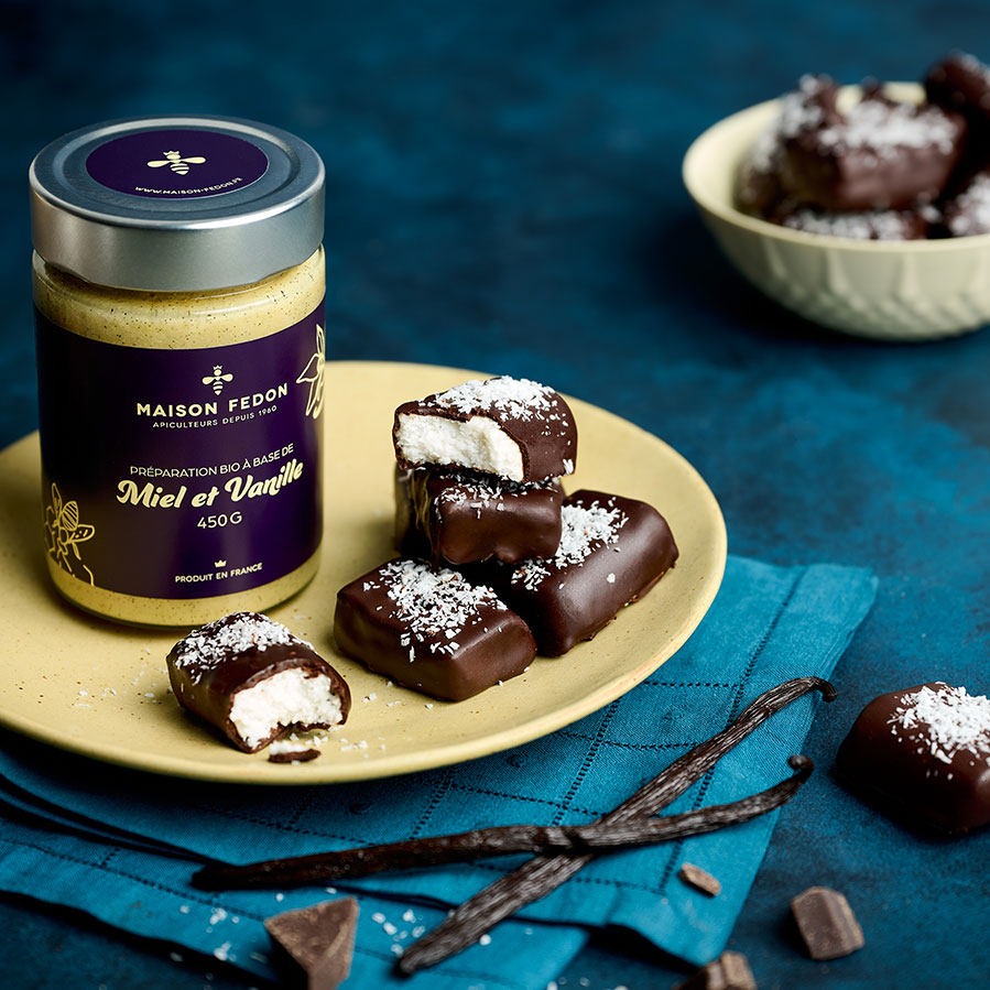 Bounty maison au miel et à la vanille, enrobés de chocolat noir et saupoudrés de noix de coco, avec le pot Miel & Vanille Maison Fedon.